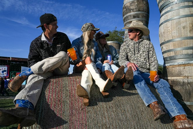 From right to left, Buck Pounds talks to Abby Nichols, Bri Duncan and Luke Nichols on a hay bale at the Two Step Inn country music festival at San Gabriel Park on Sunday, April 21, 2024 in Georgetown, Texas.